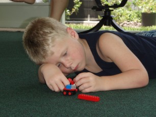A common pose for Jarin—on the floor, playing with cars