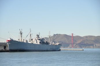 Golden Gate Bridge with military vessel in foreground