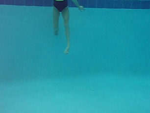 Ashlyn dives under and swims toward the camera