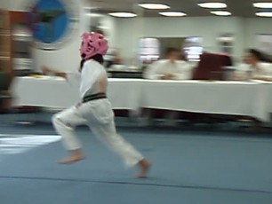 Video of young black belt recommendee performing a running kick to break a board